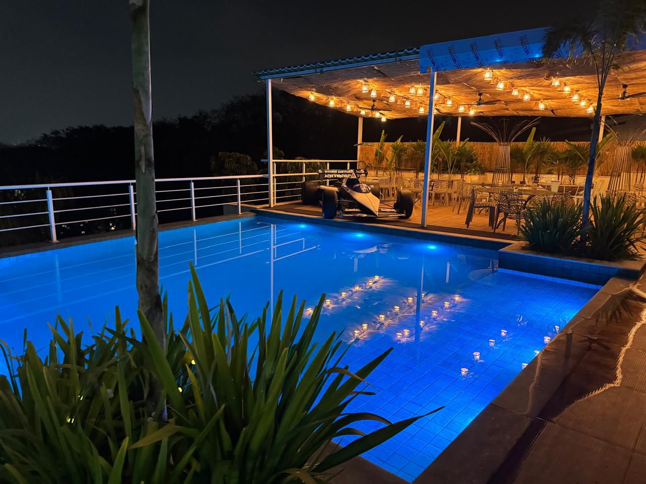 Piscina iluminada à noite com lounge